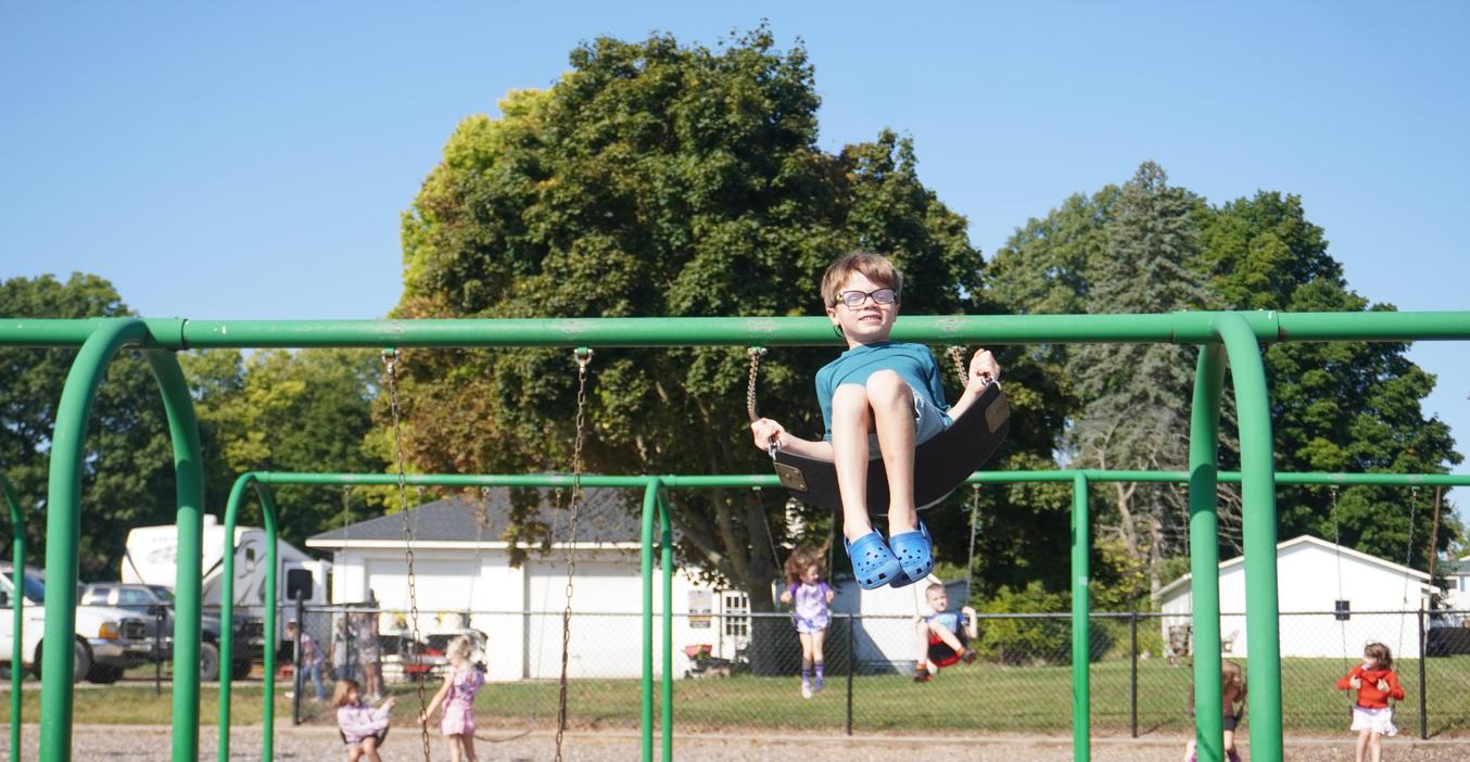 A student swings on the playground.