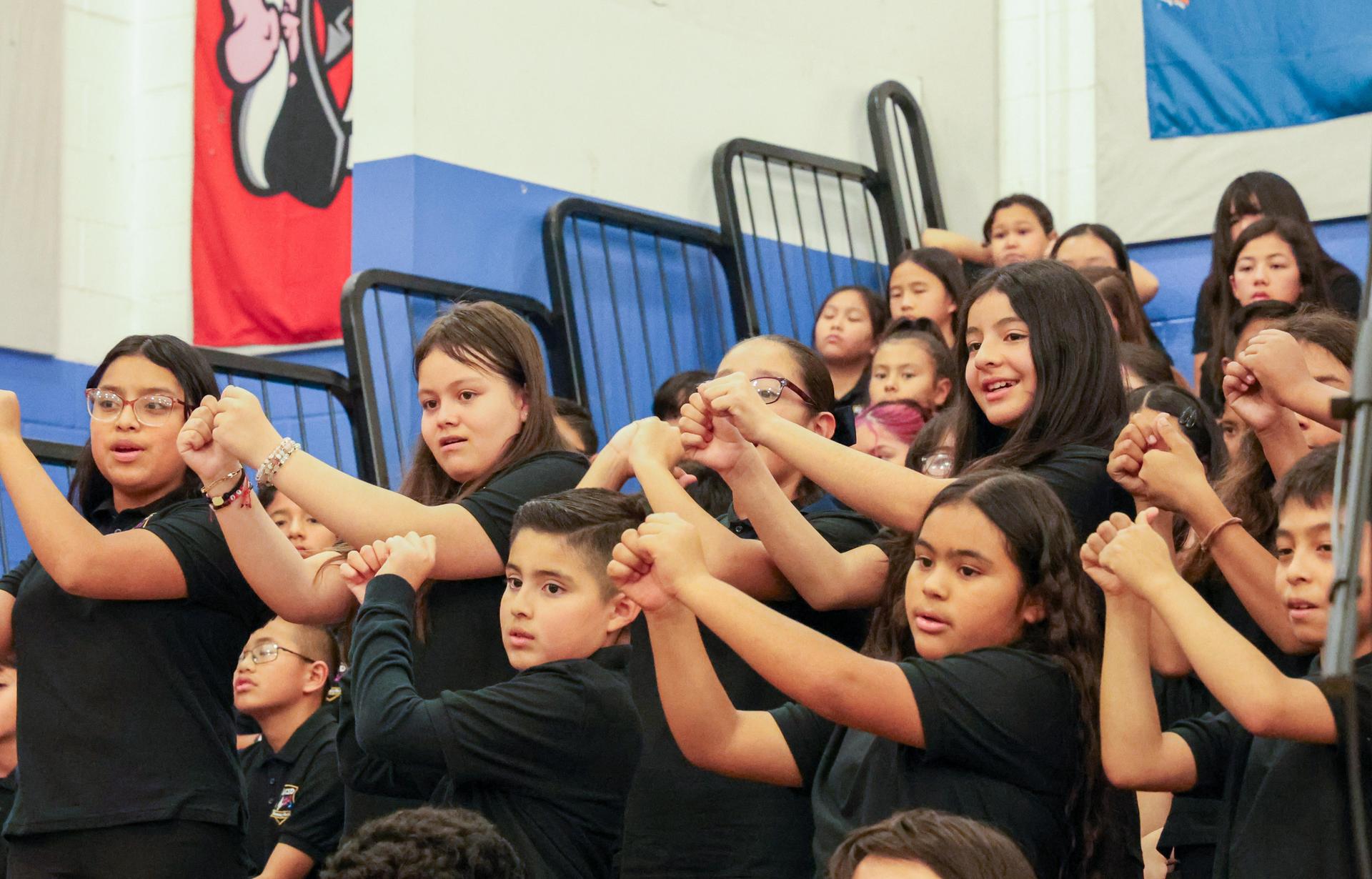 Photos of Wilkerson students singing and providing American Sign Language during their performance.
