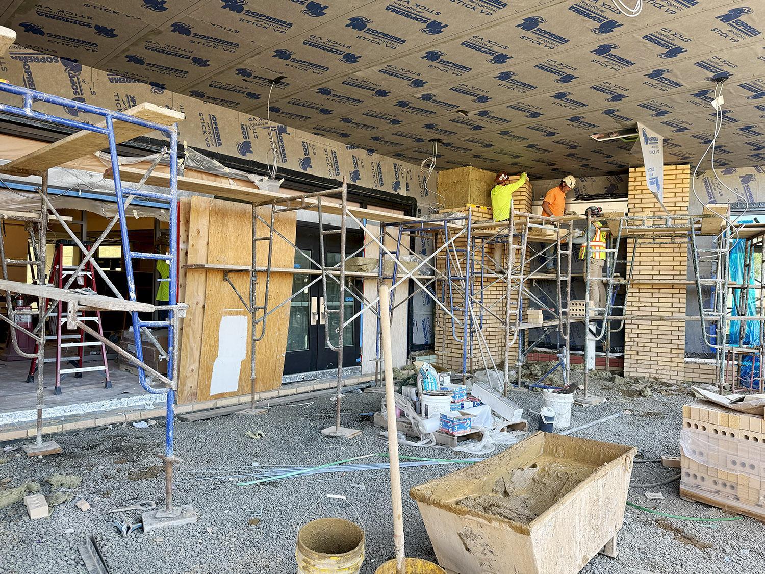 masons laying brick at front entrance
