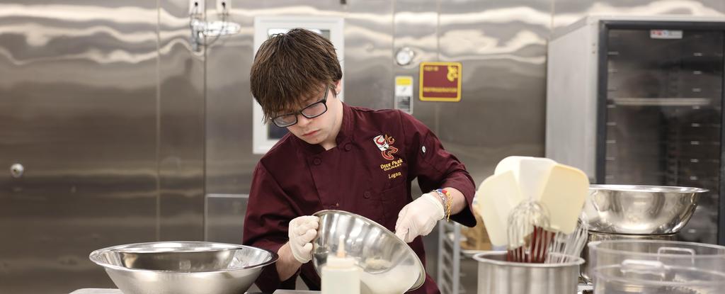 A culinary arts student prepares ingredients in a mixing bowl.