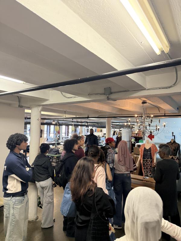 People standing and interacting in a stylish studio environment.