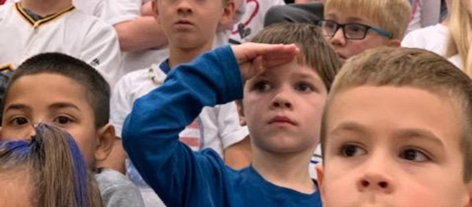 student saluting veterans