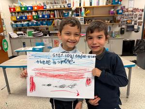 Two boys show off their completed fire safety poster