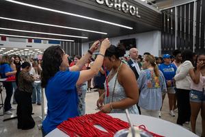 Another student being honored with a cord while others celebrate in the background.