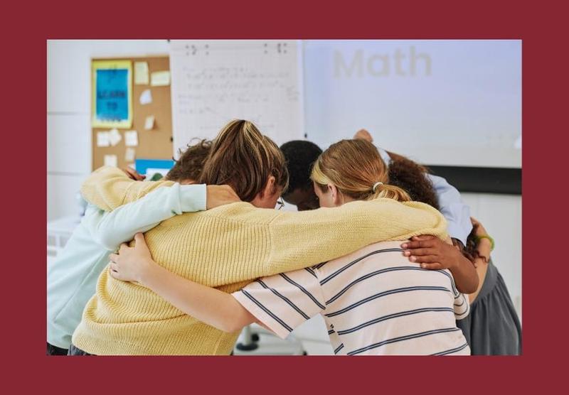 students and teacher in huddle inside gym