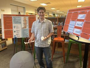 Smiling students stand with school projects