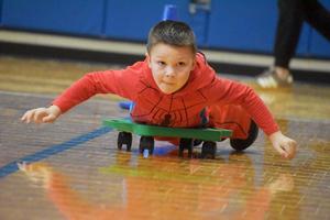 a boy riding on a floor scooter