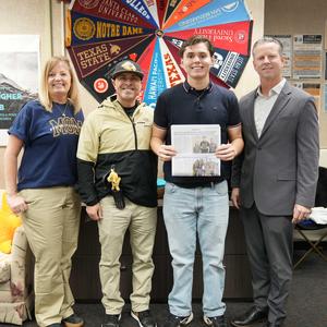 Principal, student and Superintendent with newspaper