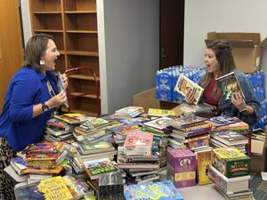 ridgewood media specialist smile with books from donation
