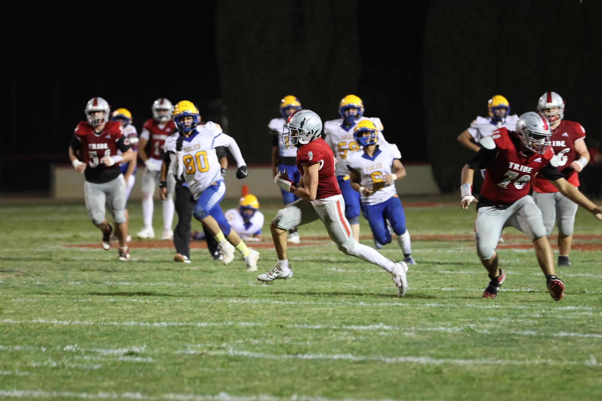 Varsity football players in action against Parlier 47