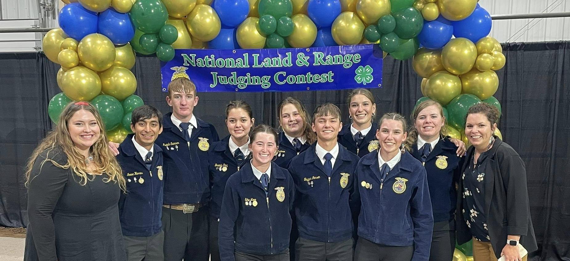FFA members posing together in formal attire with an award backdrop.
