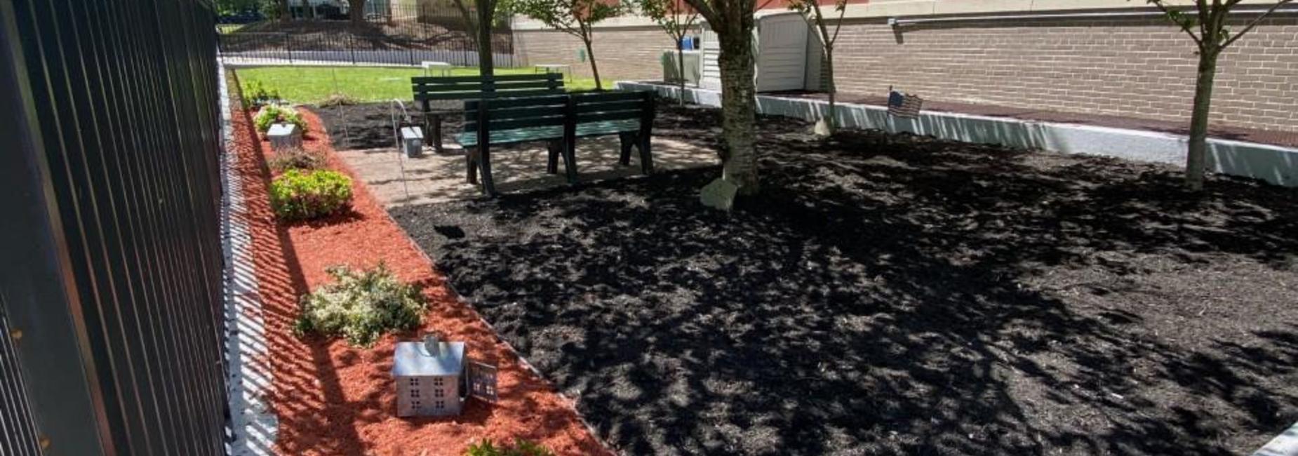 Reading garden with green benches, bushes and orange mulch