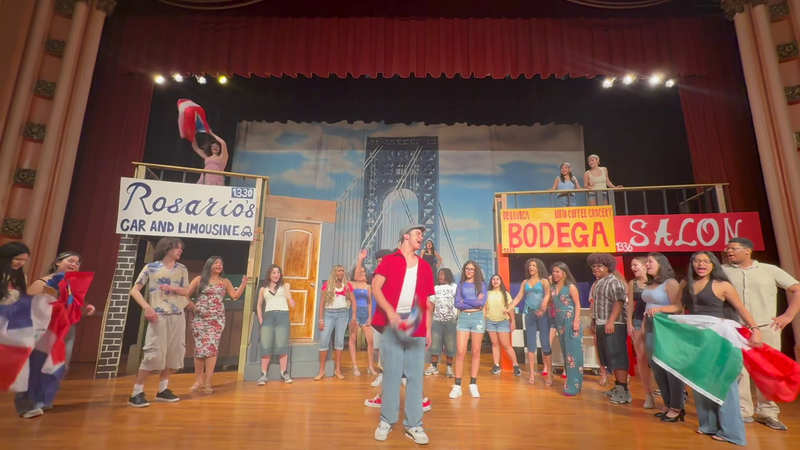 Students on stage, waving flags.