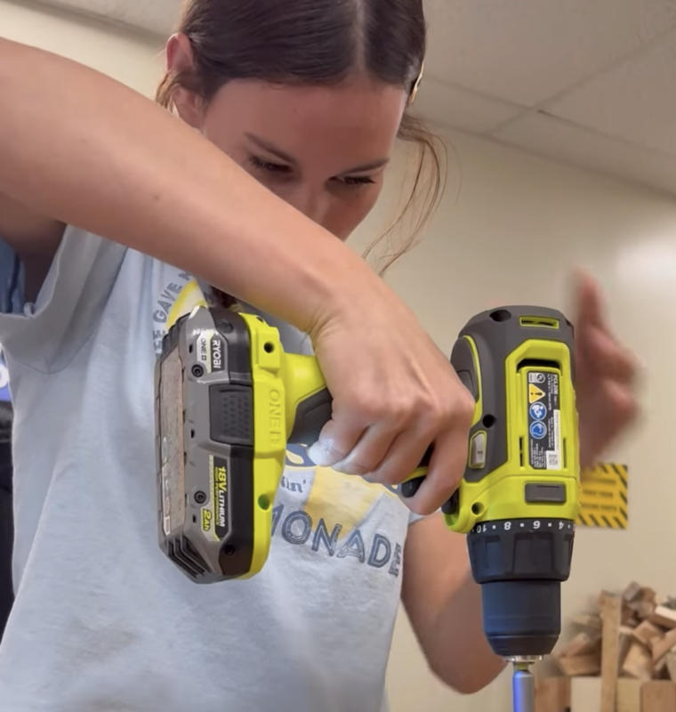 female student learning how to use the drill