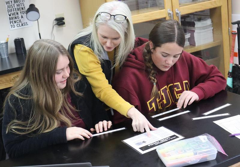 MS Science Teacher assists two students on assignment