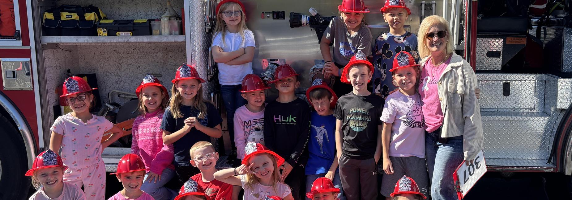 2nd grade class posing in front of a fire truck