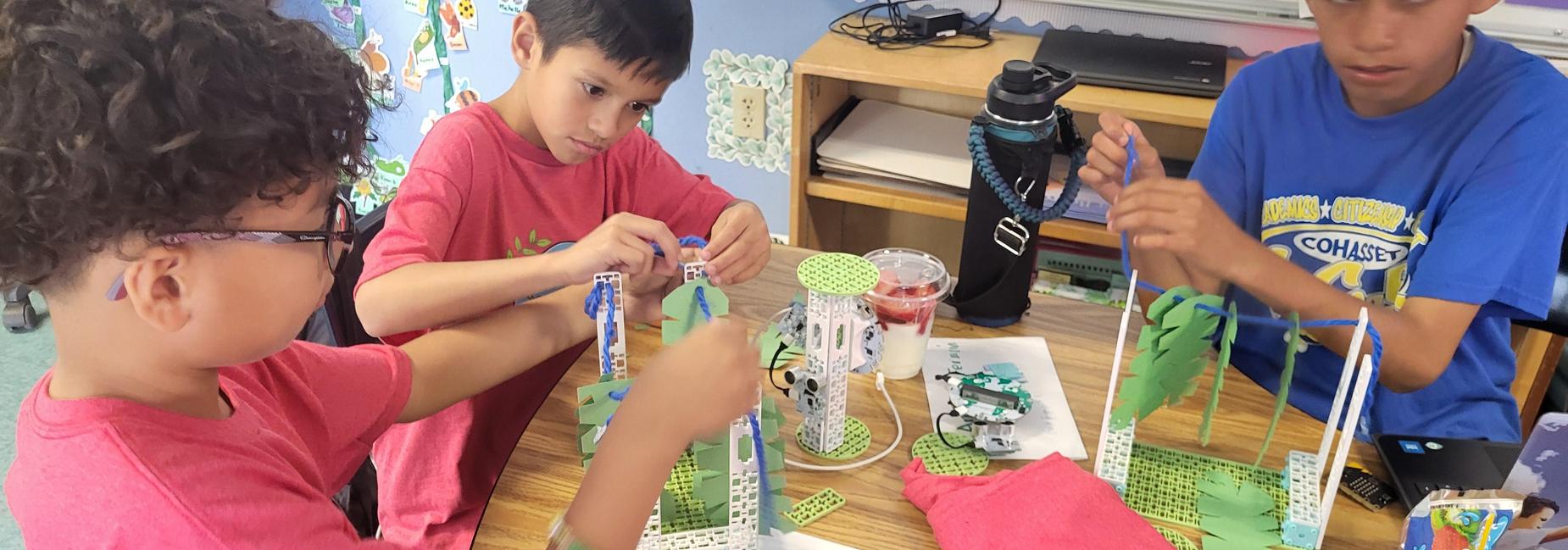 Three students building robotics models