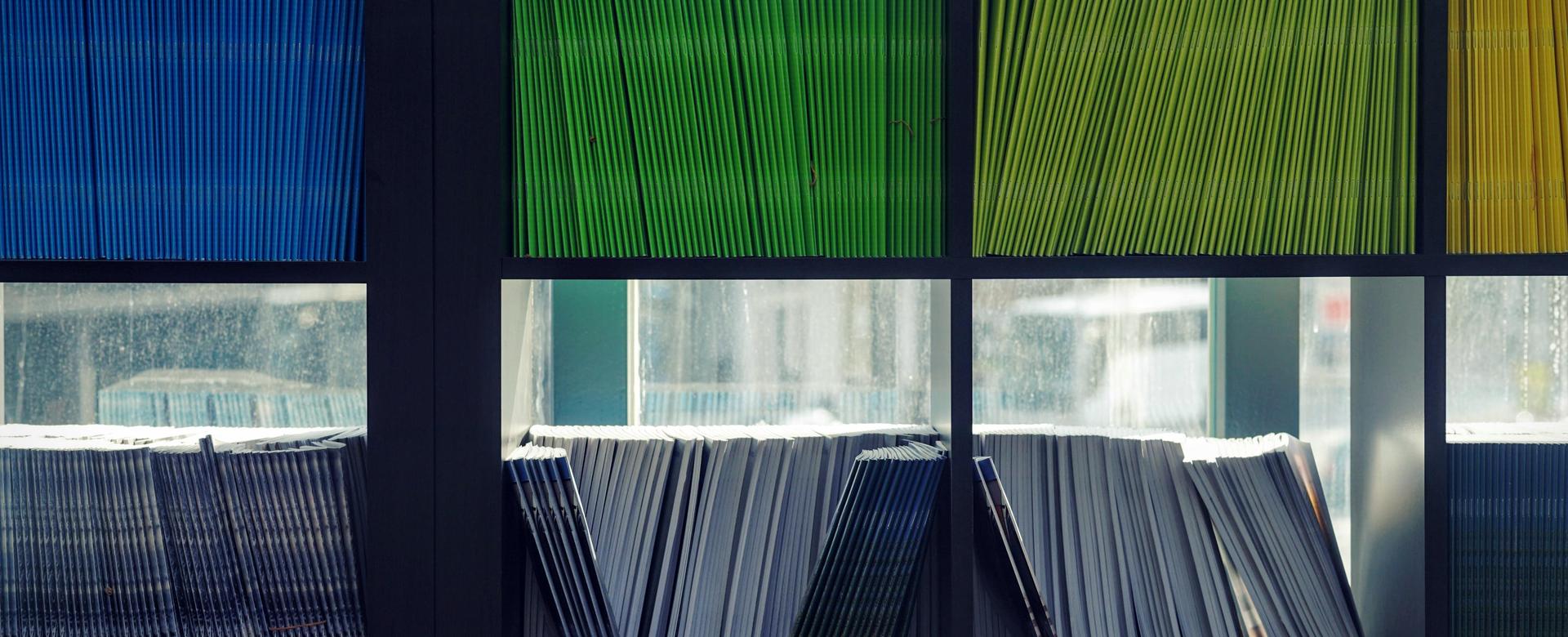 Shelves filled with neatly arranged colorful booklets and papers.