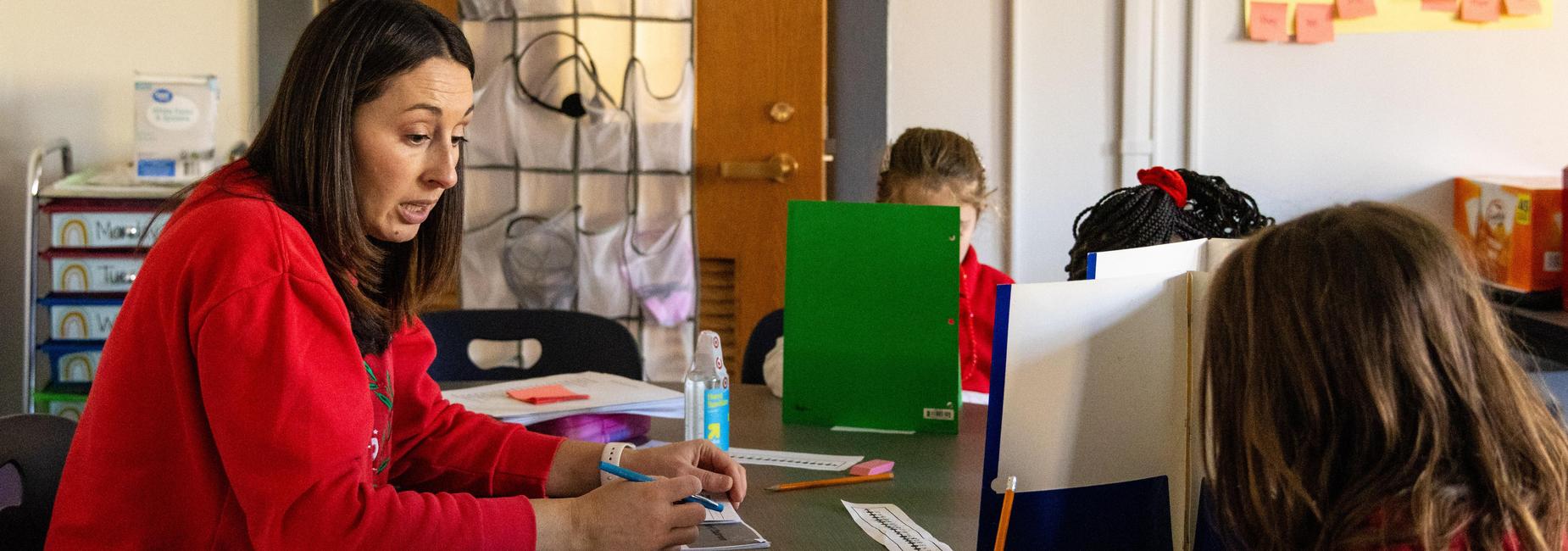 A teacher helps a student with a worksheet
