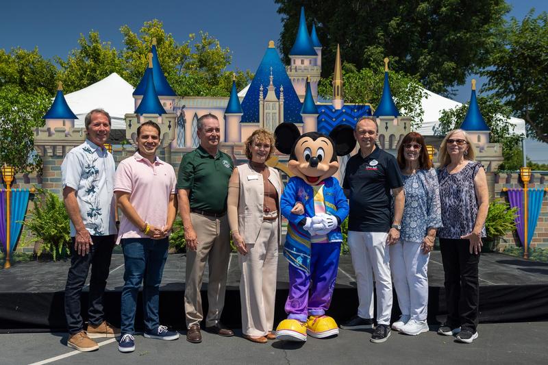 Group photo with Mickey Mouse at 70 Happiest Hours event.