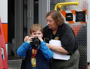 Woman helps boy with camera