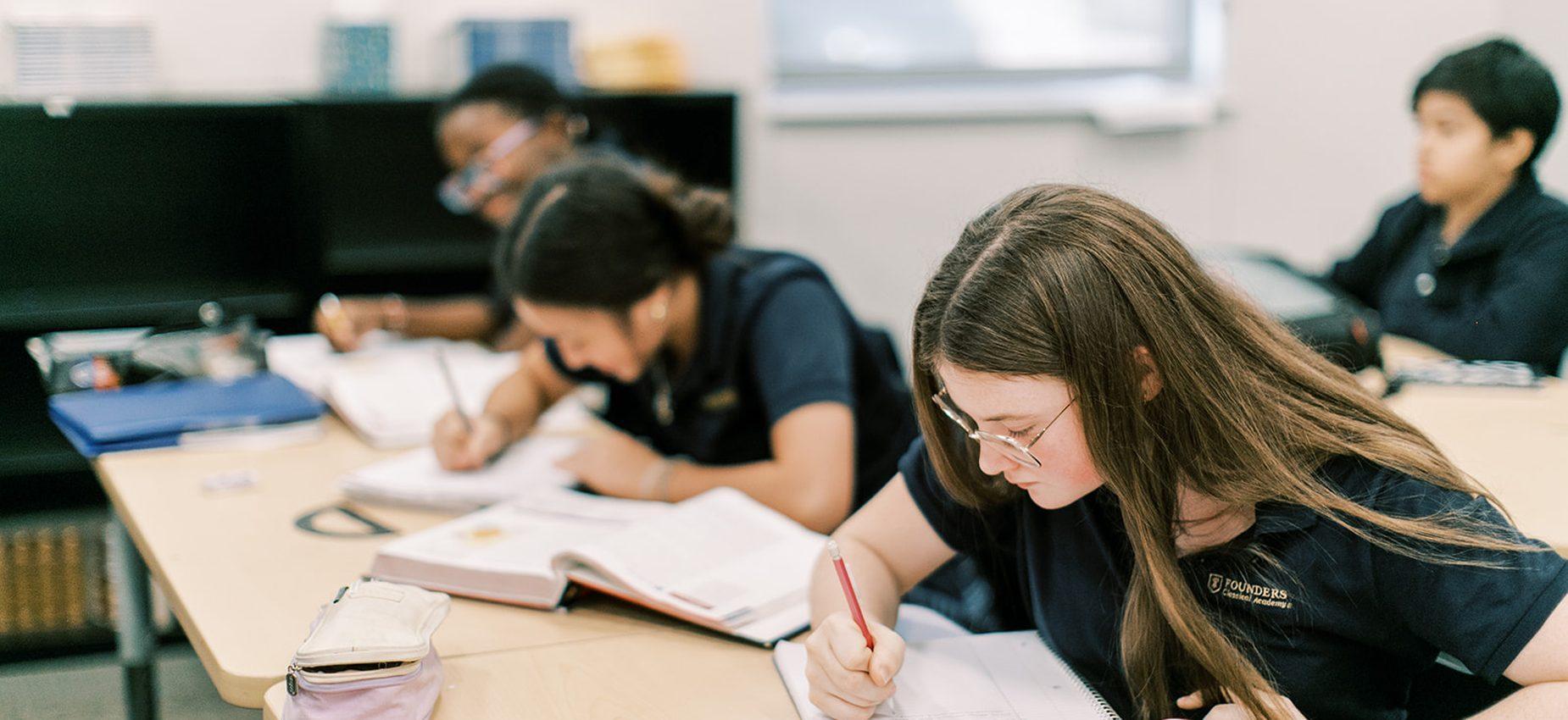 Students write in their notebooks during class