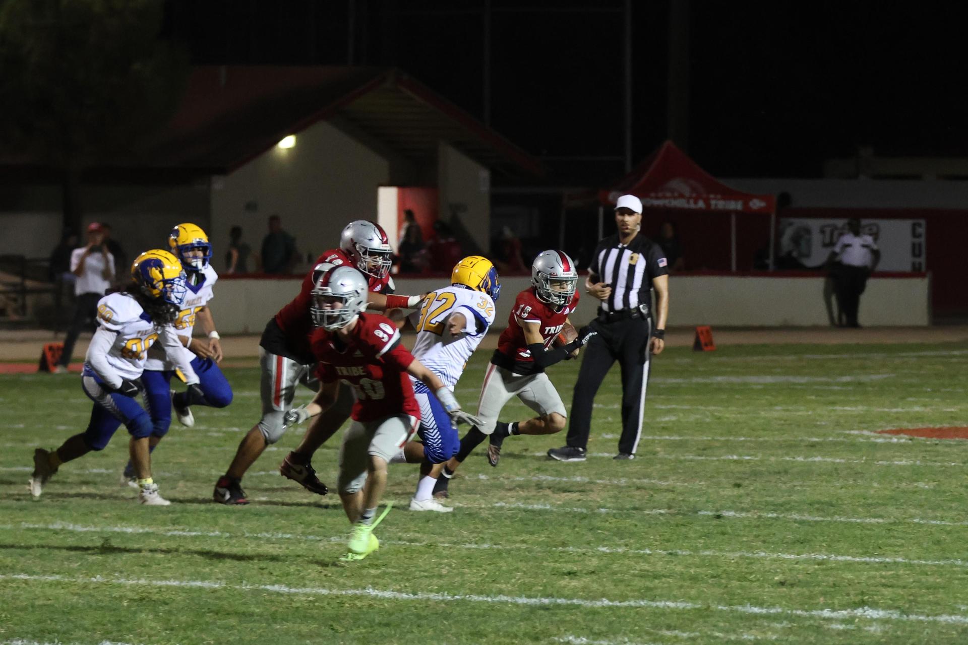 Varsity football players in action against Parlier 13