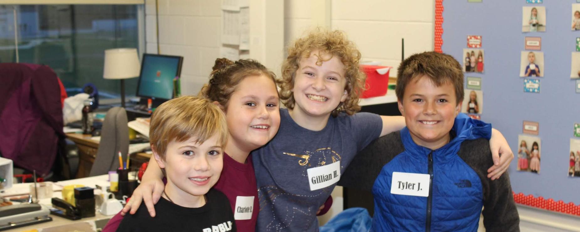 Four fifth grade students helping at the Fall Festival.