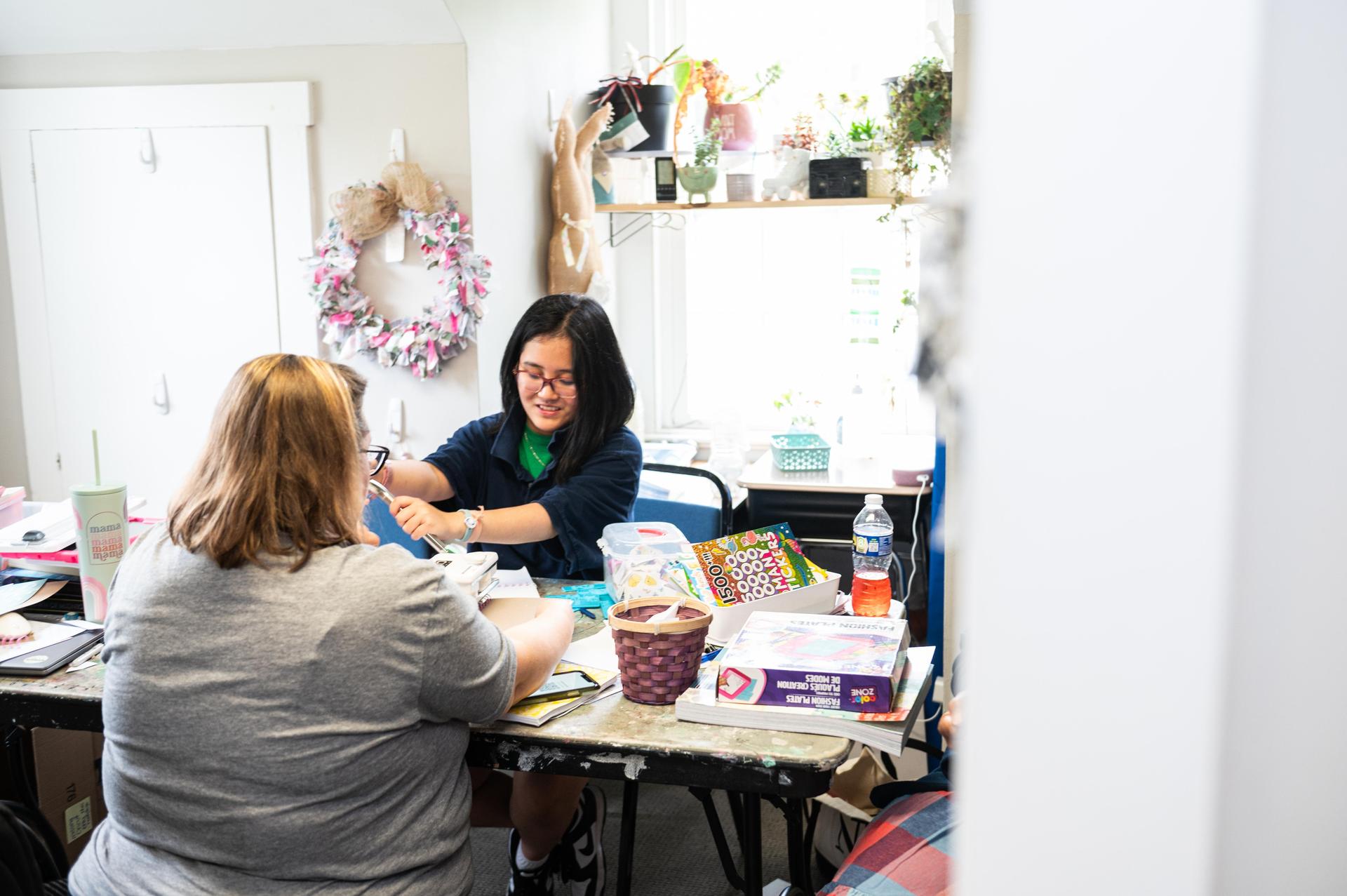 Student looking down at table making crafts.