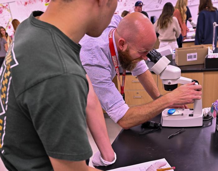 Mr. Schoenfeld looking through microscope