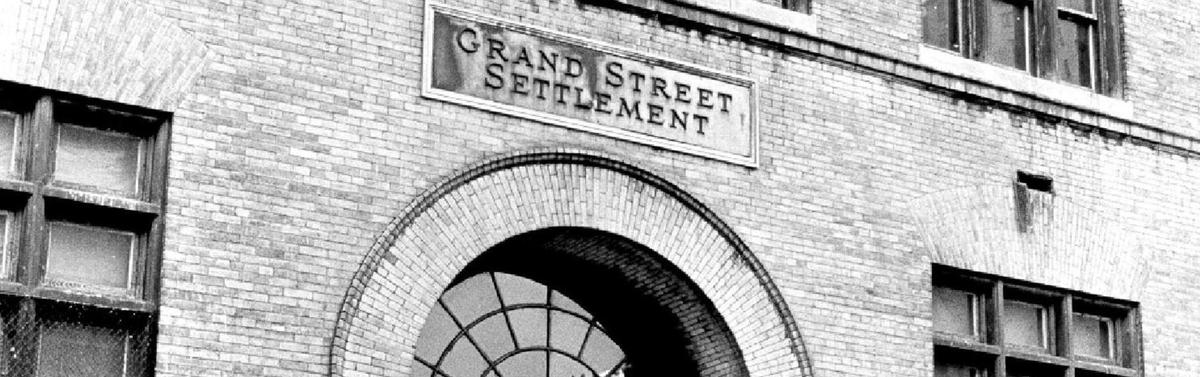 Facade of Grand Street Settlement showing an arched entrance.