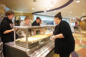 Mrs. Saxton helping students prepare to serve the breakfast.