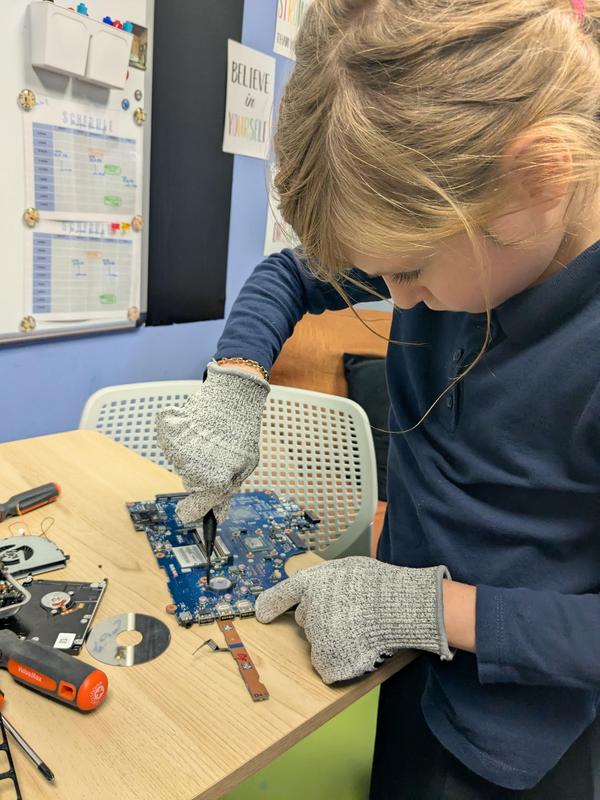 a third grade student taking apart a computer