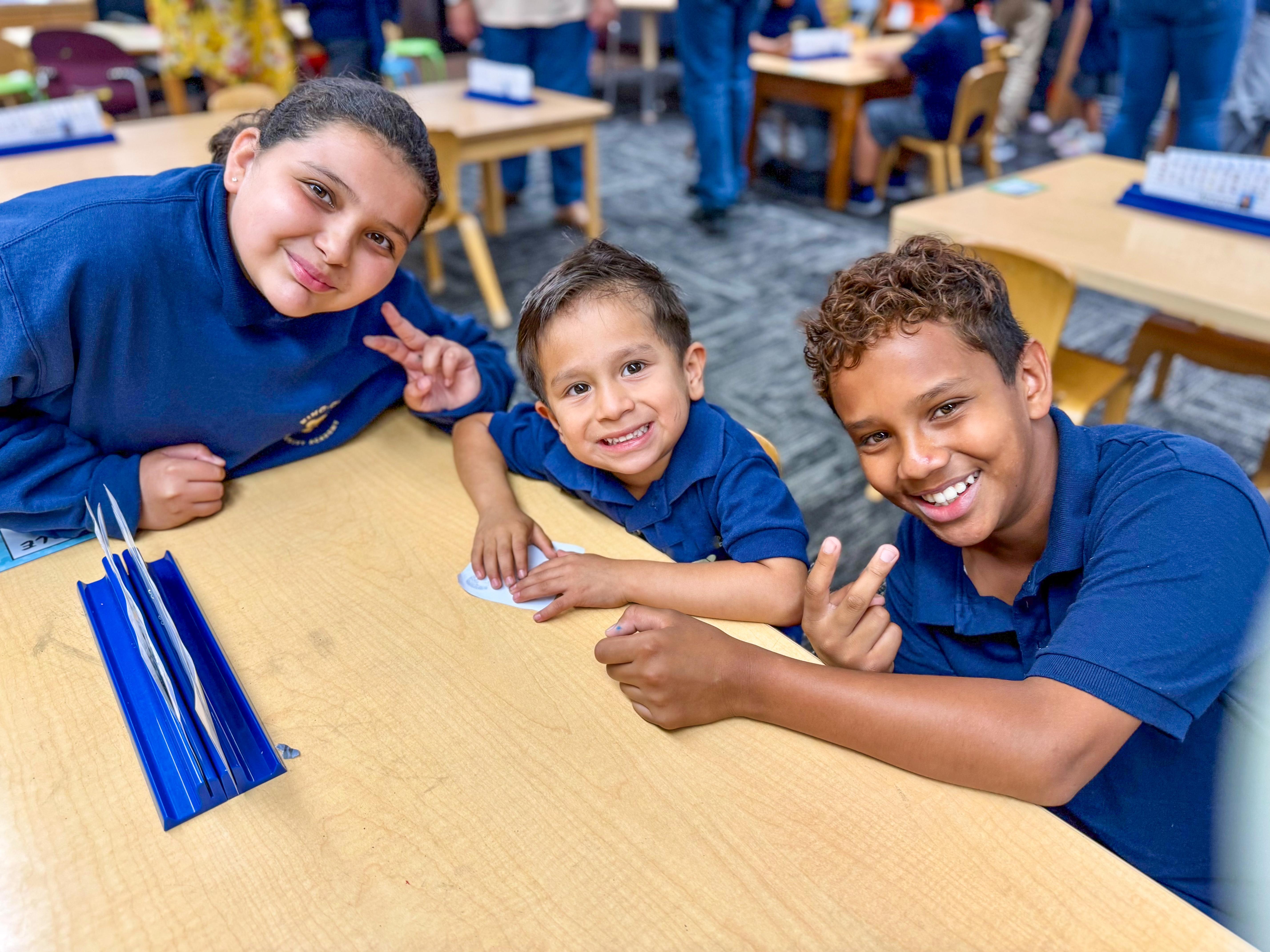 TK student seated between upper elementary students