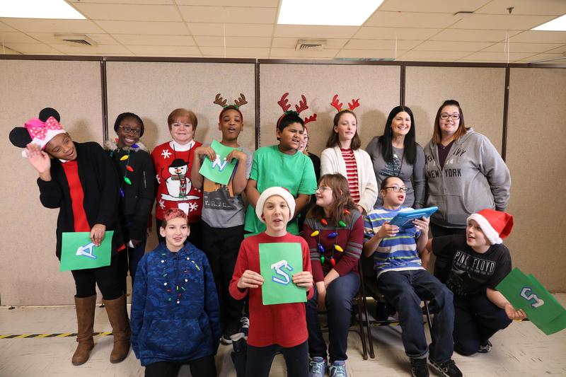 Group of students in holiday outfits looking at camera, smiling