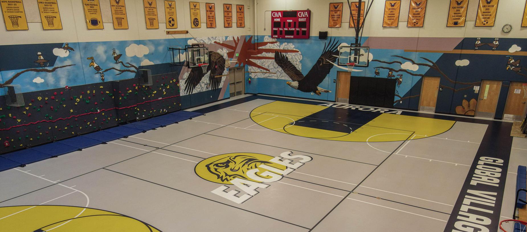 Basketball court with 'EAGLES' logo and mural in the background.