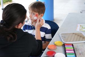 student having face painted at harvest festival