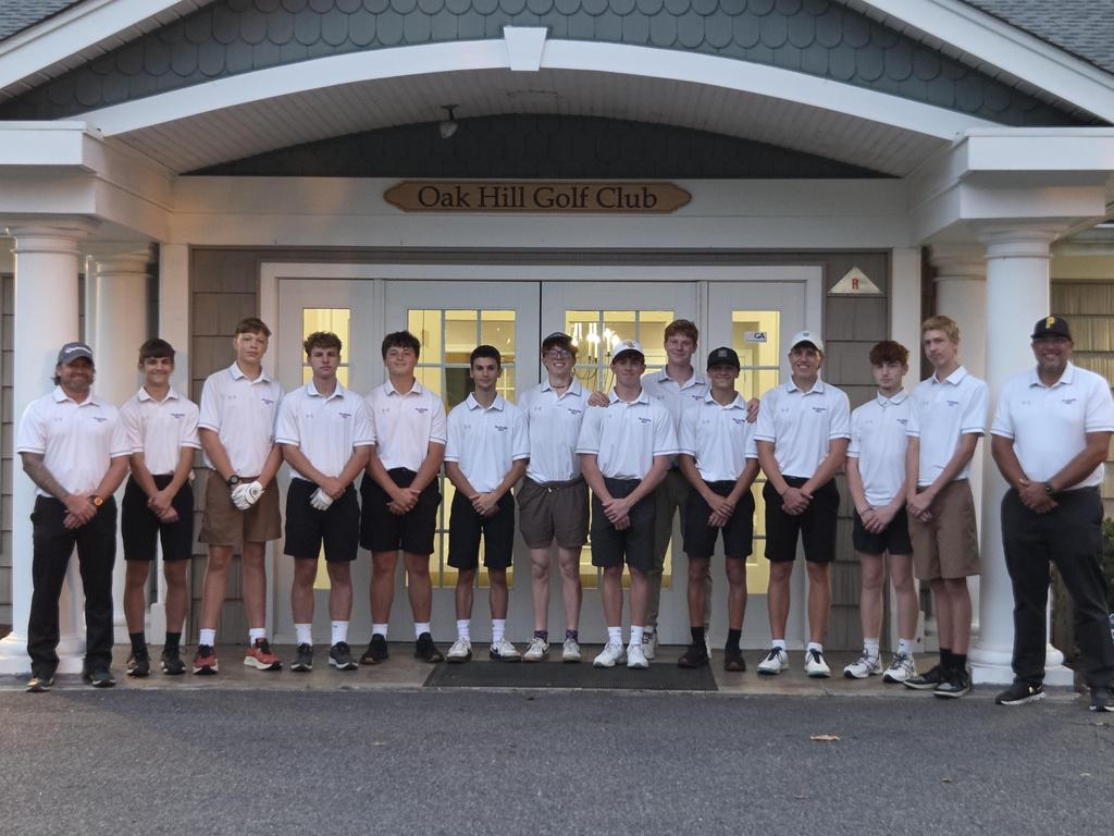 Group photo of the golf club standing in front of a building.