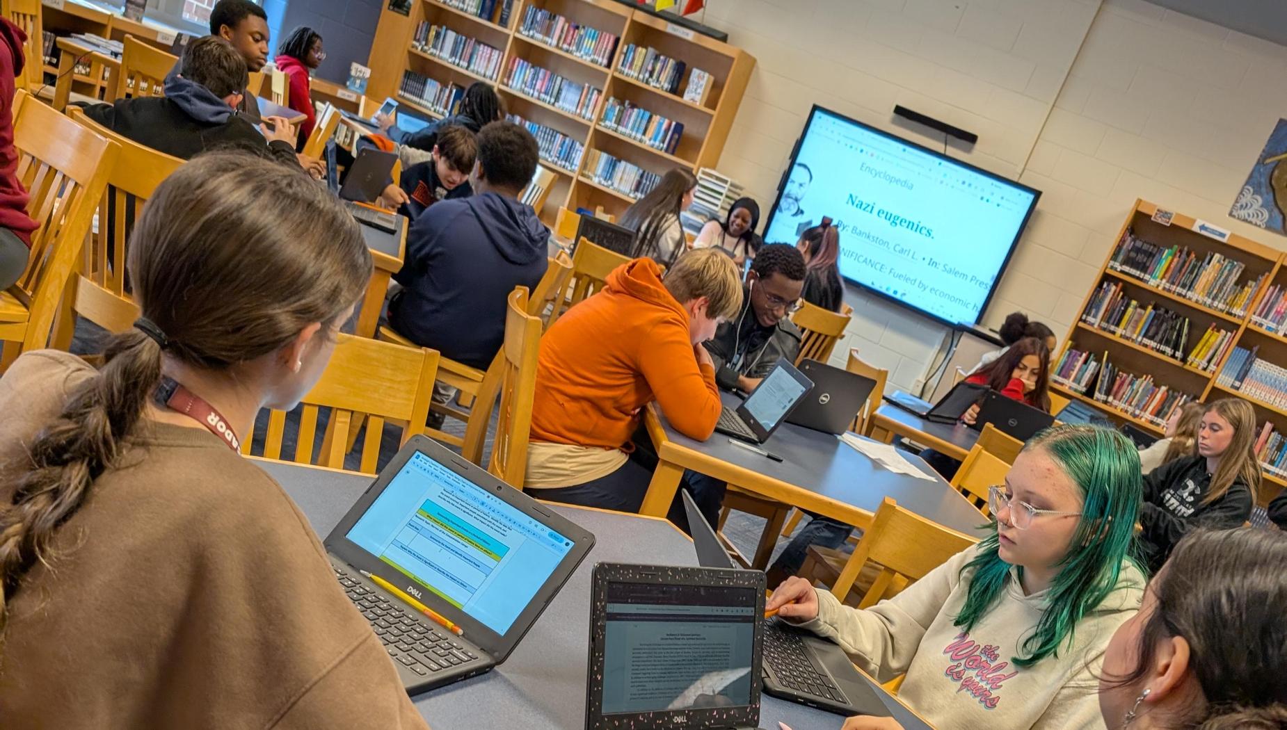 class of students on their chromebooks conducting research in the library