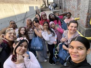 Group of young people posing for a selfie in an urban setting.
