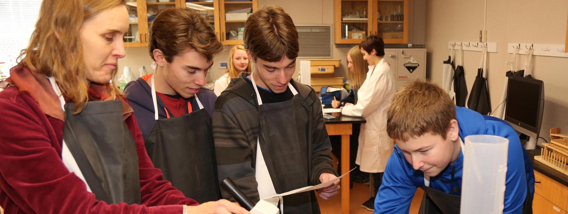 Teacher working in science lab with students.