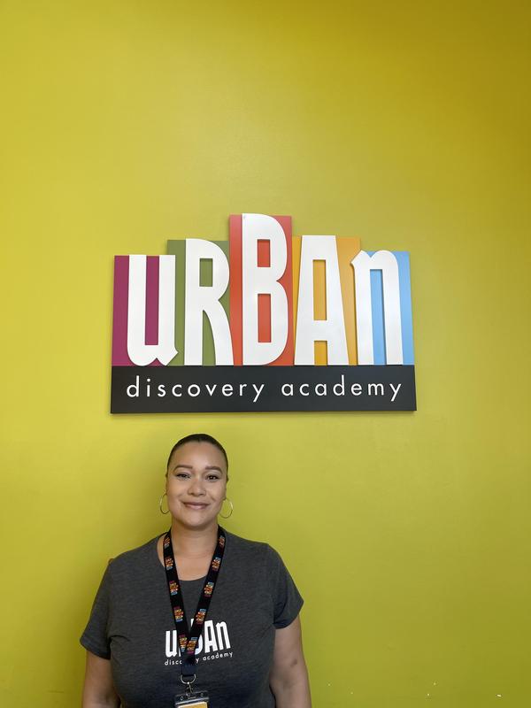 Ms. Nikia at the front office with the UDA logo.