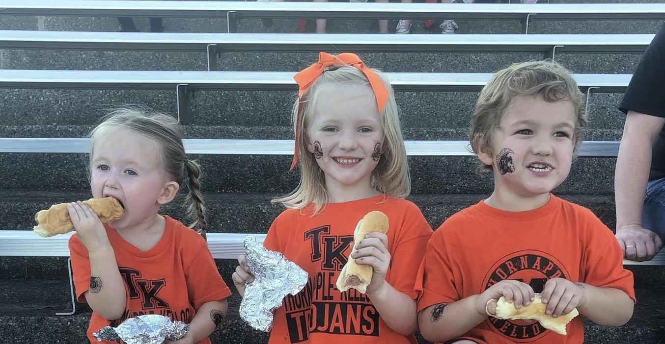Youngsters enjoy free hot dogs at the homecoming game.