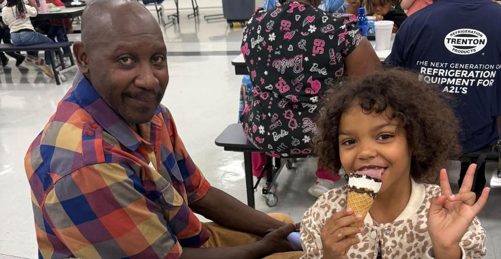 Student eating ice cream with grandparent at lunch