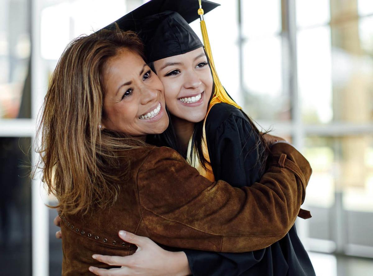 A mother hugging her daughter at a graduation ceremony