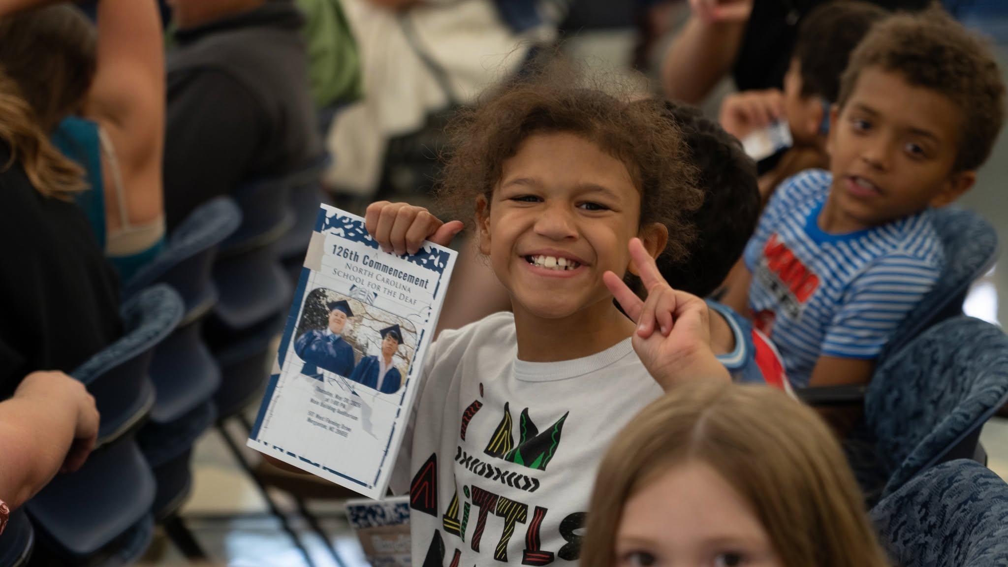Image of student smiling while holding an award