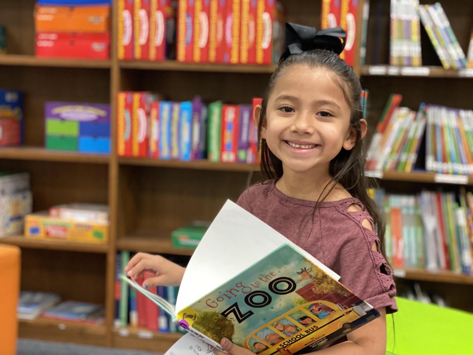 Smiling girl reading a book