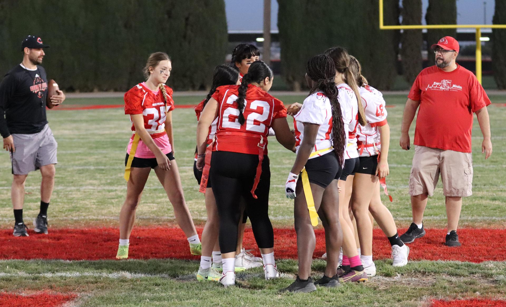 players, cheerleaders, and officials preparing for the powderpuff football game
