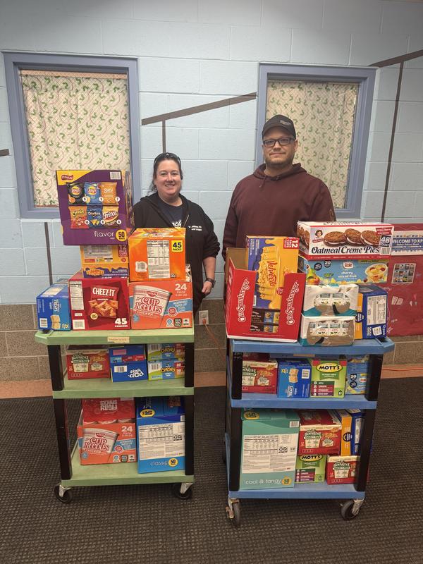 two people standing behind carts filled with food
