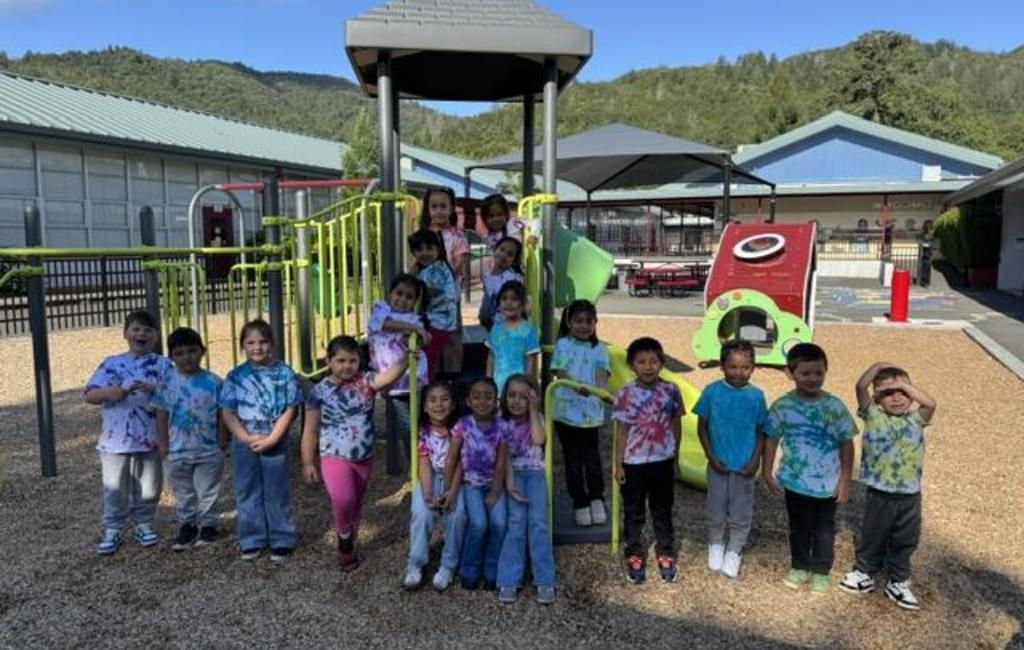 Students on the play structure wearing tie dye shirts